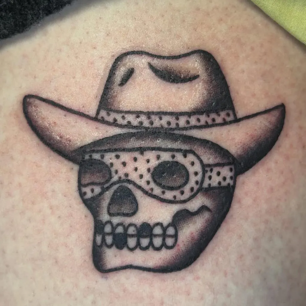 Black and grey skull in a cowboy hat with a bandana across the eyes