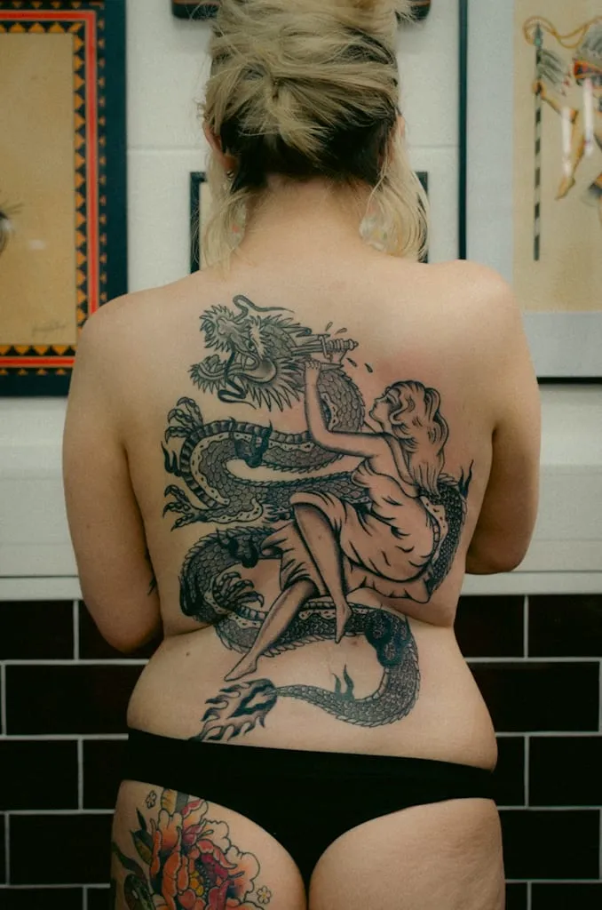 Traditional black and grey dragon and woman back piece tattoo