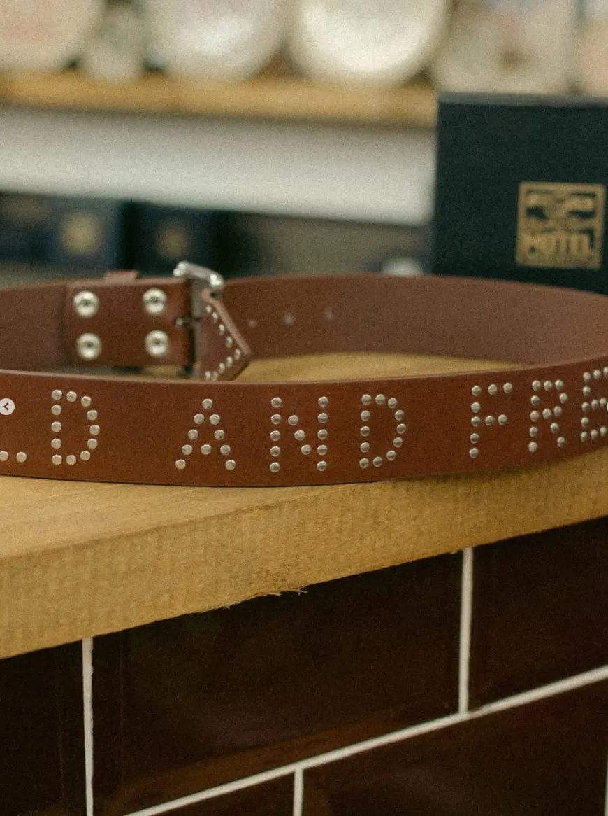 A studded leather belt reading Wild and Free