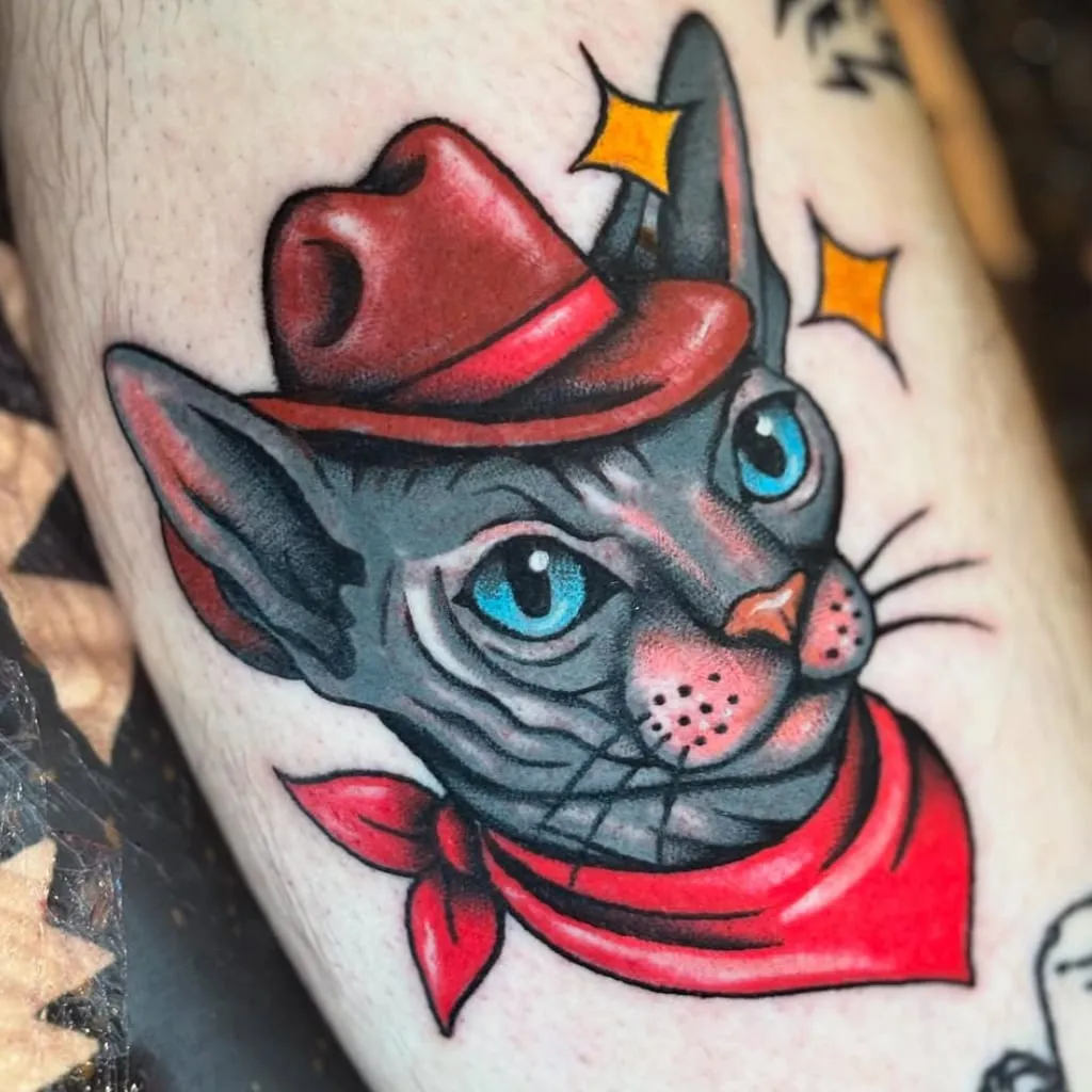Sphynx cat wearing a red cowboy hat and bandana, on a calf